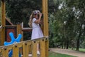 Little charming girl playing on the playground in the park, looking through toy binoculars Royalty Free Stock Photo