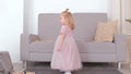 Little charming happy girl revolve in beautiful pink dress.