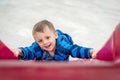 Cheeky boy on an outdoor slide