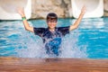 Little cheerful boy jumping to the pool and making water splash, enjoying time in the refreshing water Royalty Free Stock Photo