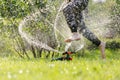 Little cheerful child playing in the garden with automatic watering lawns Royalty Free Stock Photo