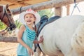 Little cheerful girl and the horse. Girl in a hat