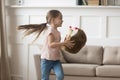 Little cheerful girl playing with stuffed toy hedgehog at home