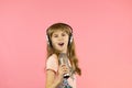 little cheerful girl sings into the microphone. Royalty Free Stock Photo