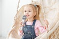 A little cheerful girl sings a song into the microphone. The con