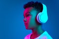 Little cheerful happy boy 6-7 years old wearing white t-shirt and headphones listen to music isolated on blue background Royalty Free Stock Photo