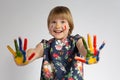 A little cheerful smiling girl shows her paint-stained hands Royalty Free Stock Photo