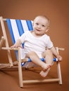 Little cheerful toddler sitting on the sunbed Royalty Free Stock Photo