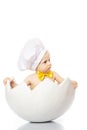 Little Chef. baby boy dressed in s chef`s hat sitting in egg shell. isolated on white background