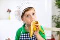 Little chef eating a banana Royalty Free Stock Photo