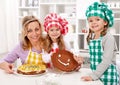 Little chef girls with their mother making a cake