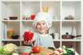 Little chef holding fresh red peper. Son preparing healthy food for family dinner. Child want to be a professional chef