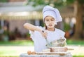 Little chef whipping eggs in a bowl outdoors