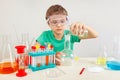 Little chemist in safety goggles doing chemical experiments in laboratory Royalty Free Stock Photo