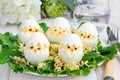 Little chicken in the nest, deviled eggs served with salad and dry ramen on white plate, horizontal