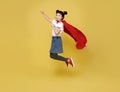 Little child asian girl plays superhero on yellow background studio shot. Girl power hero concept Royalty Free Stock Photo
