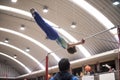 Little child athletic gymnast performing exercises at the bar in the championship Royalty Free Stock Photo