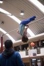 Little child athletic gymnast performing exercises at the bar in the championship Royalty Free Stock Photo