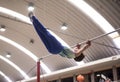 Little child athletic gymnast performing exercises at the bar in the championship Royalty Free Stock Photo