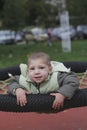 Little child in autumn jackets swinging in a swing Royalty Free Stock Photo