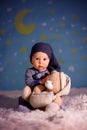 Little baby boy with cute teddy bear and moon on a blue star and Royalty Free Stock Photo