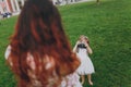 Little child baby girl in light dress take picture of mom on retro vintage photo camera on green grass in park. Mother Royalty Free Stock Photo