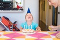 Little child with birthday cake horselaughing next to woman