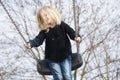 Little child blond girl having fun on a swing outdoor. Royalty Free Stock Photo