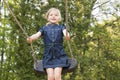 Little child blond girl having fun on a swing outdoor. Royalty Free Stock Photo