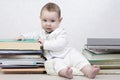 Little child among books. Happy six month old baby boy in a stack of books Royalty Free Stock Photo