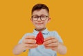 Little child boy in glasses holds a strawberry in hand.