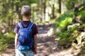 Little child boy with hikers backpack travelling in forest