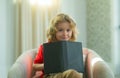 Little child boy lying on the couch at home and reading a childrens story book. Concept of education, childhood, book Royalty Free Stock Photo