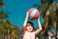 Little child boy playing basketball with basket ball. Kid with basket ball on sky background, cheerful and pleasant. Royalty Free Stock Photo
