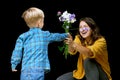 Little child boy present mother bouquet of wild flowers. Son greeting mom with birthday or mother`s day Royalty Free Stock Photo