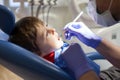 Little child, boy, sitting on a dentist chair, having his yearly