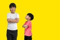 Little child boy and tall child boy standing arms crossed and looking face isolated on yellow background. Big and small kid