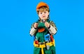 Little child in builder uniform and construction helmet with wrench. Kid boy with toolbelt. Little kid in overalls and Royalty Free Stock Photo