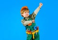 Little child in builders uniform and hard hat with toy tools. Kid playing with repair tools. Cute boy with toolbelt of Royalty Free Stock Photo