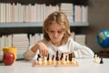 Little child chessman play chess game, checkmate. Kid playing chess in the room.