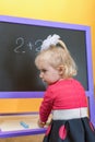 A little child chooses color crayons for drawing on a children`s school board Royalty Free Stock Photo