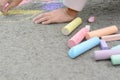 Little child drawing butterfly and hearts with chalk on asphalt, closeup