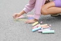 Little child drawing butterfly and hearts with chalk on asphalt, closeup Royalty Free Stock Photo
