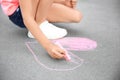 Little child drawing heart with chalk on asphalt Royalty Free Stock Photo