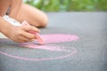 Little child drawing heart with chalk on asphalt, Royalty Free Stock Photo