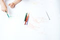 Little child draws on white paper with colored felt-tip pens, teaching children to draw Royalty Free Stock Photo