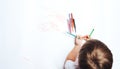 Little child draws on white paper with colored felt-tip pens, teaching children to draw Royalty Free Stock Photo