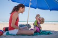 Little child drinking from pack with mother at beach Royalty Free Stock Photo