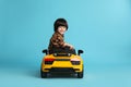 Little child driving yellow toy car on light blue background Royalty Free Stock Photo