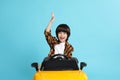 Little child driving yellow toy car on light blue background Royalty Free Stock Photo